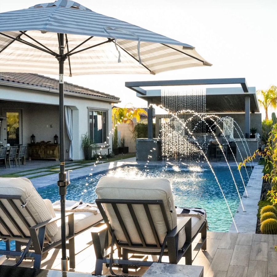 Resort-style pool with striped umbrella and clean cream loungers