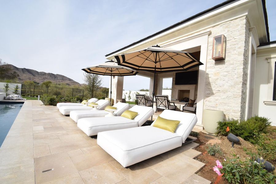 Luxury estate poolside with white loungers and umbrellas